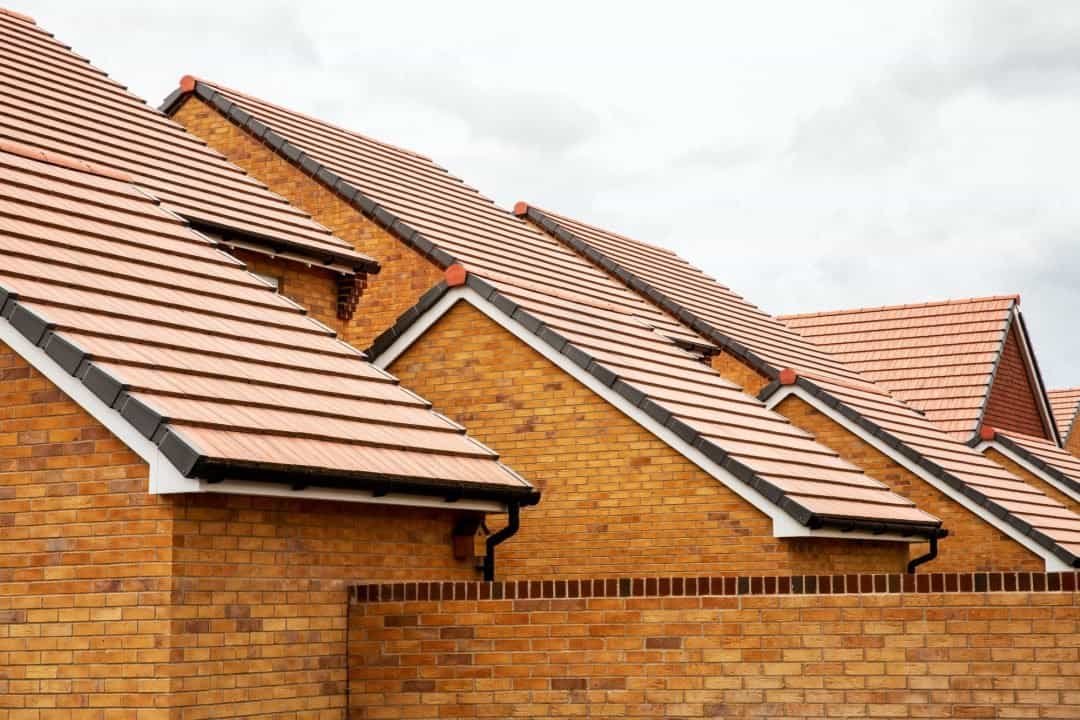 Stylish red brick homes with modern roofing tiles, showcasing expert roofing and construction craftsmanship. Perfect for residential building projects.